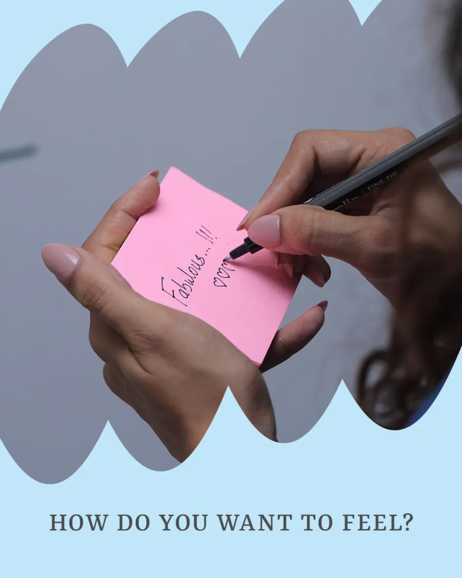 A hand writes 'Fabulous' on a pink sticky note